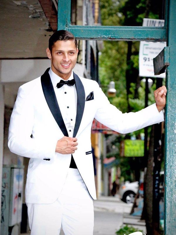 Novio con smoking blanco y solapa negra en día de boda